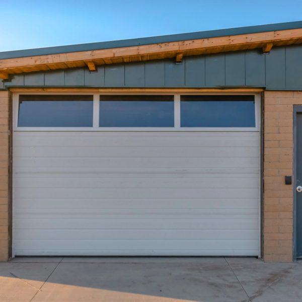 white garage door next to grey personnel door